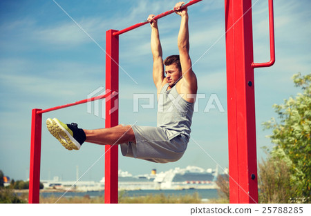 young man exercising on horizontal bar outdoors 25788285