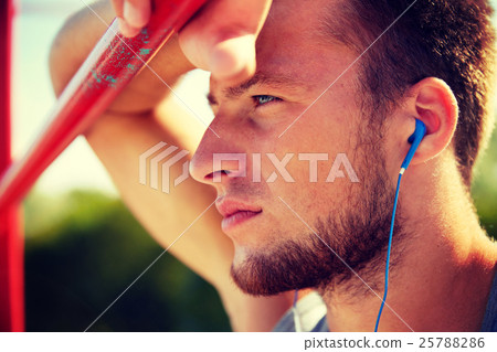 young man with earphones and horizontal bar 25788286
