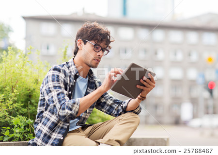 man with tablet pc sitting on city street bench 25788487