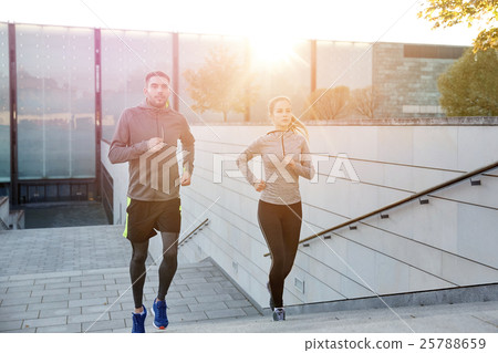happy couple running upstairs on city stairs 25788659