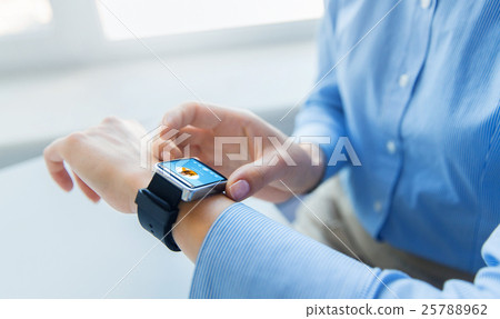 close up of hands with music player on smart watch 25788962