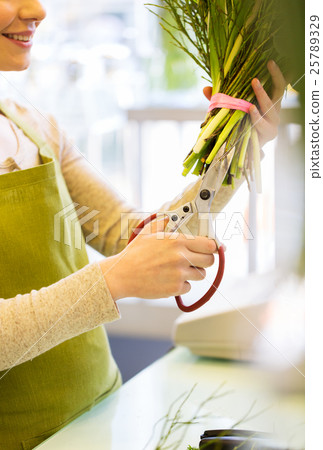 close up of woman with flowers and scissors 25789329