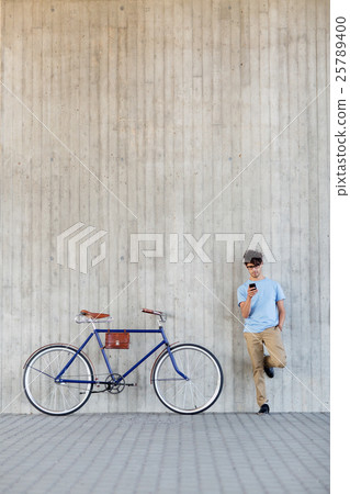 man with smartphone and fixed gear bike on street 25789400