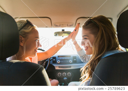 happy teenage girls or women driving in car 25789623