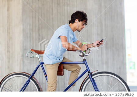 man with smartphone and earphones on bicycle man with smartphone and earphones on bicycle 25789630