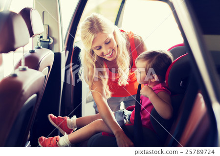 happy mother fastening child with car seat belt 25789724