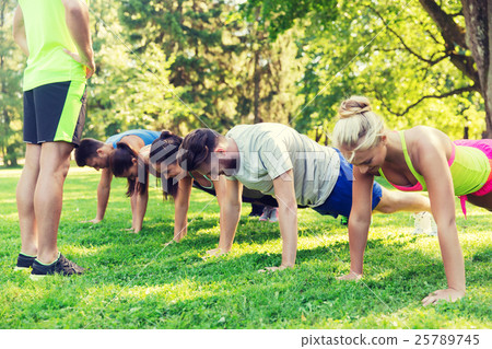 group of friends or sportsmen exercising outdoors 25789745