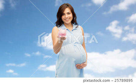 happy pregnant woman with piggybank over blue sky 25789895