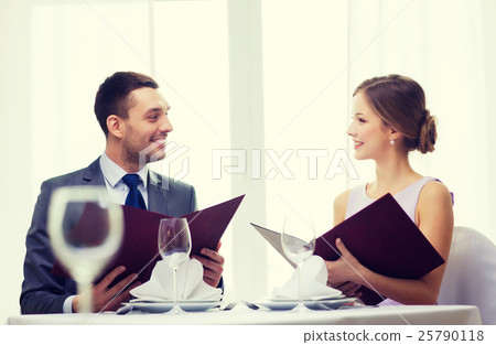 smiling couple with menus at restaurant smiling couple with menus at restaurant 25790118