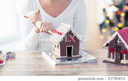 close up of woman making gingerbread houses 25790453