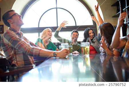 friends with beer watching football at bar or pub 25790752