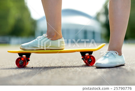 close up of female feet riding short skateboard 25790776