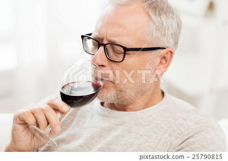 senior man drinking red wine from glass at home senior man drinking red wine from glass at home 25790815