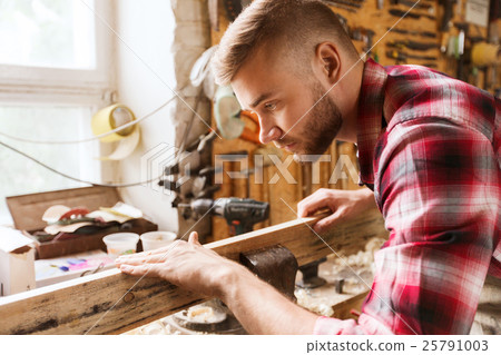 carpenter working with wood plank at workshop carpenter working with wood plank at workshop 25791003