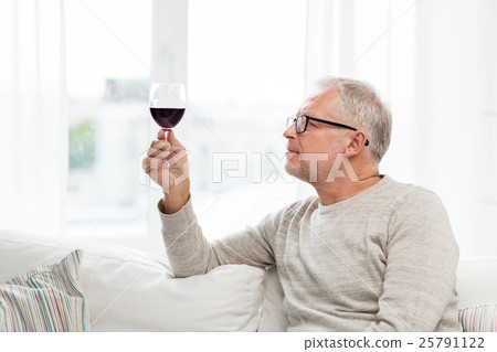 senior man drinking red wine from glass at home senior man drinking red wine from glass at home 25791122