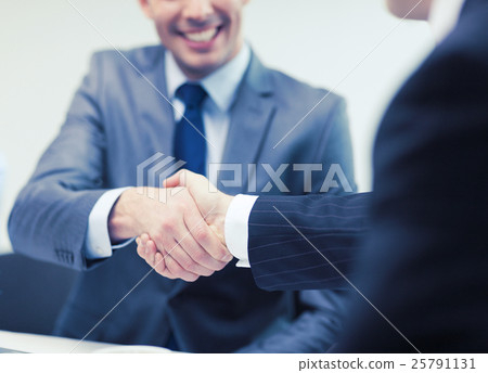 two businessmen shaking hands in office two businessmen shaking hands in office 25791131