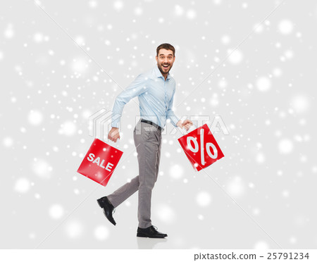 smiling man with red shopping bags over snow smiling man with red shopping bags over snow 25791234