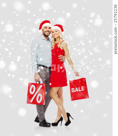 happy couple with red shopping bags over snow 25791236