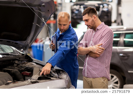 auto mechanic with clipboard and man at car shop 25791879