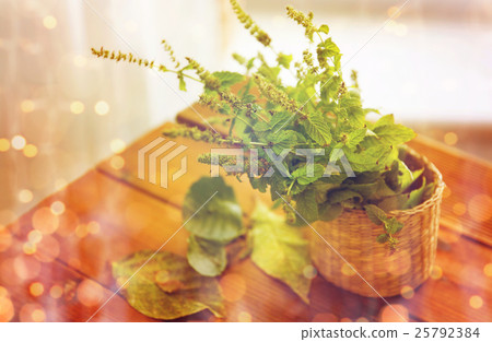 close up of melissa in basket on wooden table 25792384