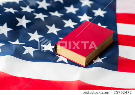 close up of american flag and book close up of american flag and book 25792472