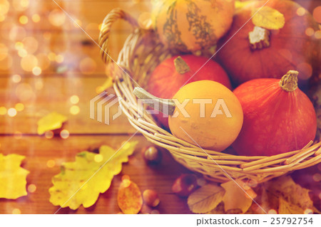 close up of pumpkins in basket on wooden table 25792754