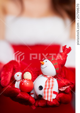 Small snowman with red scarf and hat at the hands Small snowman with red scarf and hat at the hands 25799670