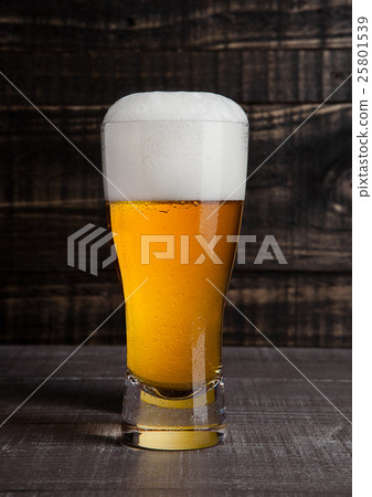 Glass of beer with frost on wood background 25801539
