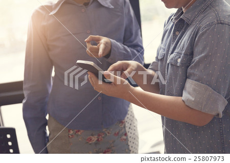 women look at mobile phone in meeting room 25807973