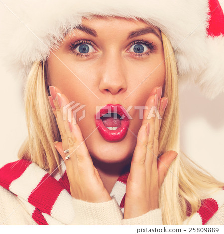 A woman wearing a Santa hat A woman wearing a Santa hat 25809889