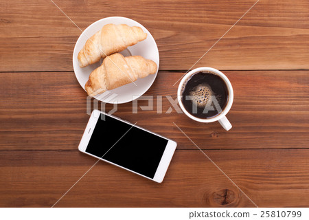 Cup of coffee and croissants mobile phone. Cup of coffee and croissants mobile phone. 25810799
