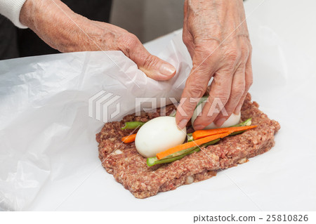 Rolling up the Egg and Vegetables stuffed meatloaf Rolling up the Egg and Vegetables stuffed meatloaf 25810826