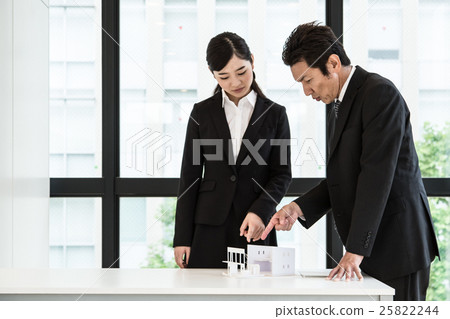 Business men and women examining houses in the office 25822244