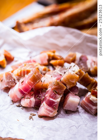 Raw smoked bacon slices on wooden board with cumin Raw smoked bacon slices on wooden board with cumin 25823613