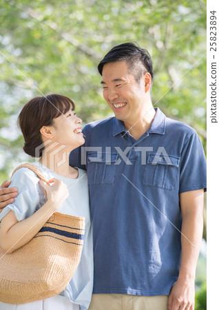 A couple walking through the sunbeams through the sun A couple walking through the sunbeams through the sun 25823894