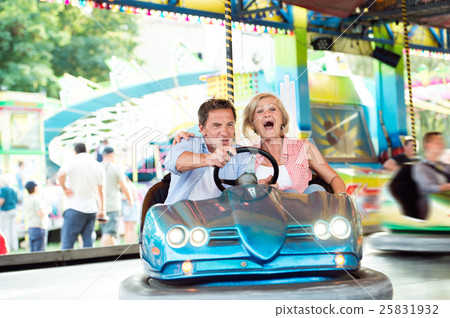 Senior couple in the bumper car at the fun fair Senior couple in the bumper car at the fun fair 25831932