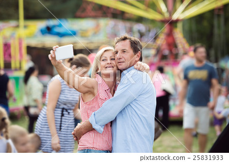Senior couple having a good time at the fun fair Senior couple having a good time at the fun fair 25831933