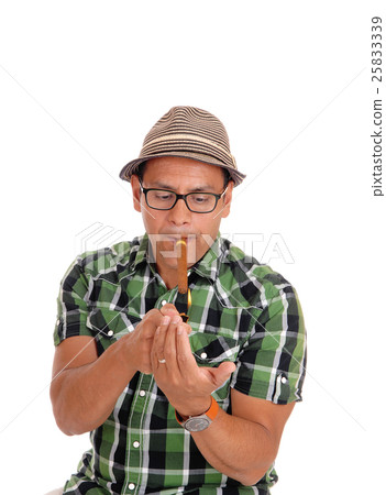 Hispanic man lightning his cigar. Hispanic man lightning his cigar. 25833339