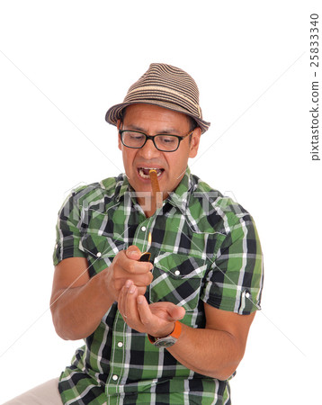 Hispanic man try to light his cigar. Hispanic man try to light his cigar. 25833340