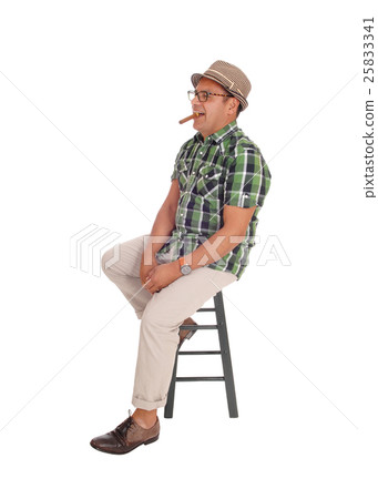 Hispanic man smoking his cigar. Hispanic man smoking his cigar. 25833341