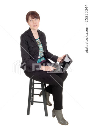 Woman sitting with a laptop on her lap. Woman sitting with a laptop on her lap. 25833344