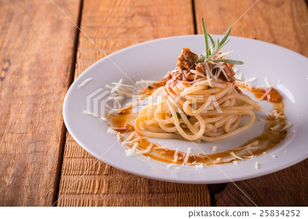 Plate with portion of spaghetti on wooden board 25834252