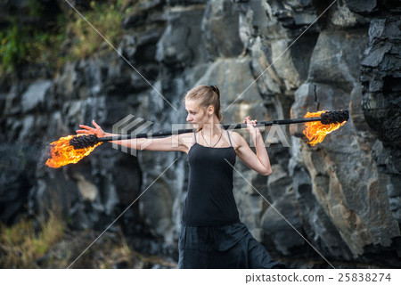 Girl in a black suit with flaming torches . Girl in a black suit with flaming torches . 25838274