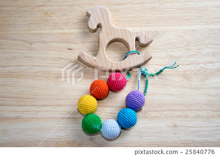 Sling beads with horse toy on a wooden table 25840776