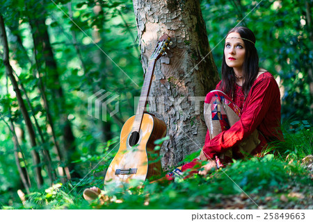 Hippie girl with the guitar in the woods 25849663