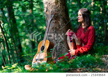 Hippie girl with the guitar in the woods Hippie girl with the guitar in the woods 25849664