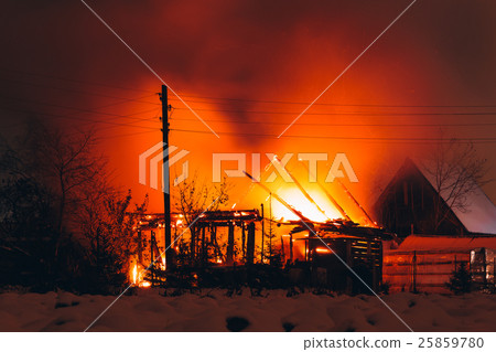 fire in a wooden house at night 25859780