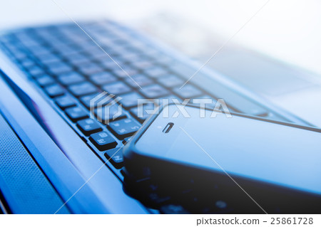 Closeup picture of a keyboard with a phone 25861728