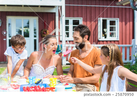 Family having coffee in garden, eating cake Family having coffee in garden, eating cake 25870950
