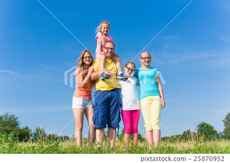 Family standing on meadow - father with children Family standing on meadow - father with children 25870952